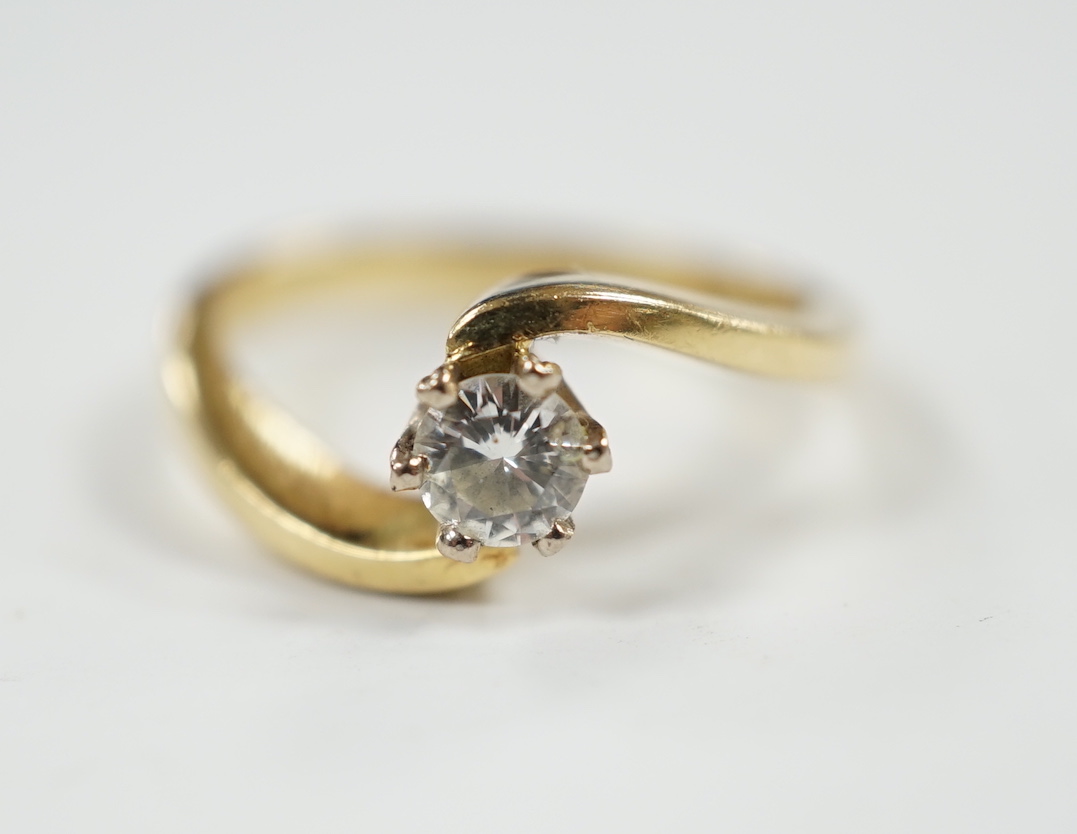 A modern 18ct gold and solitaire diamond set ring, with crossover shoulders, size K, gross weight 4 grams.